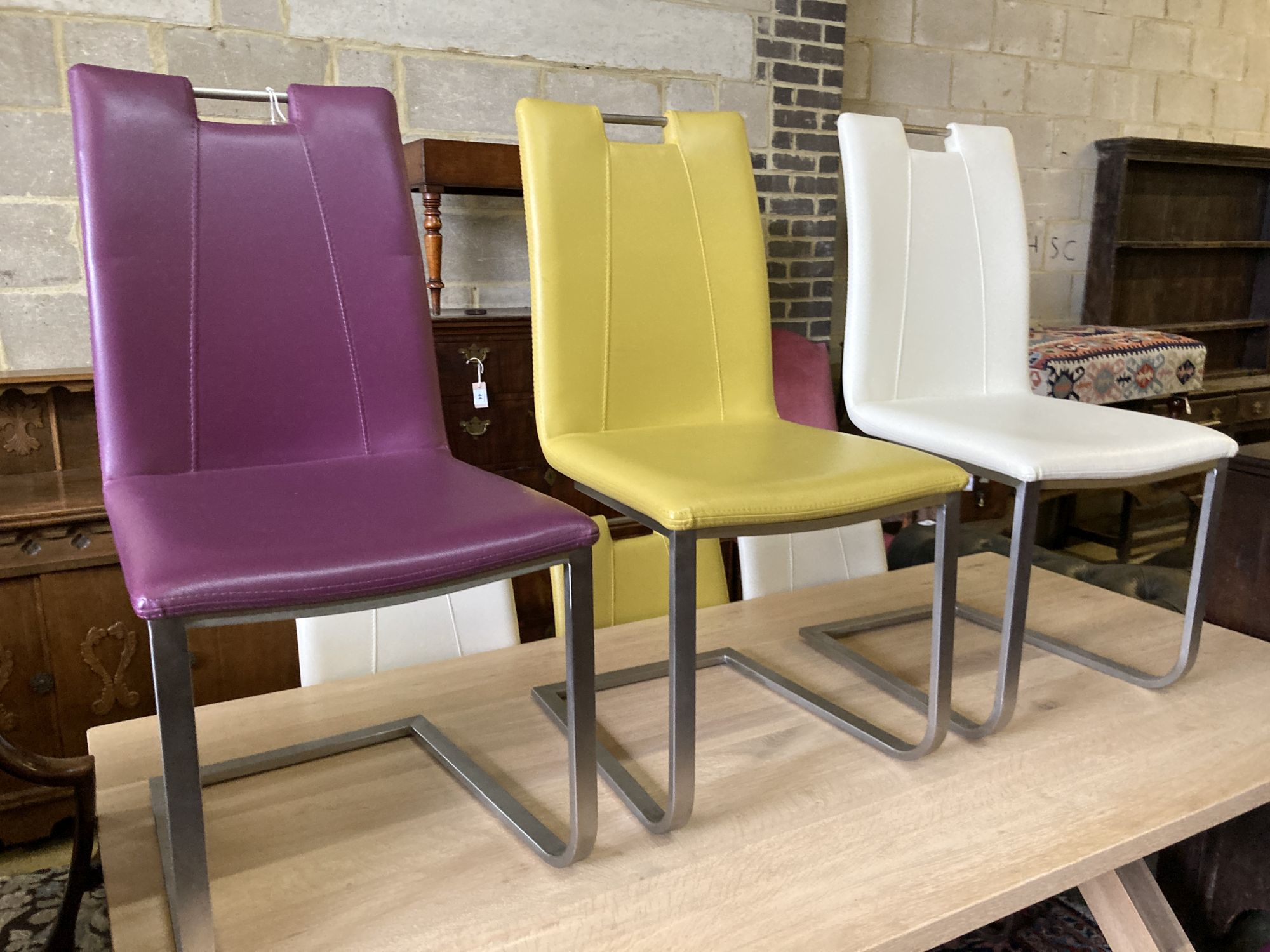 A set of eight contemporary stainless steel and leather-covered dining chairs